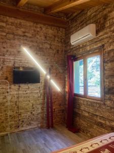 a light in a room with a tv and a window at Home Cervino Apartments in Antey-Saint-André