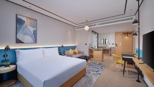 een hotelkamer met een groot bed en een woonkamer bij Hilton Garden Inn Liaocheng Jiangbei Shuicheng in Liaocheng