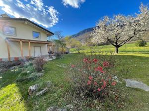 une maison avec un jardin fleuri dans la cour dans l'établissement La Casina di Oscar ad AO V Combe VDA QUART 0014 e OOI6, à Quart