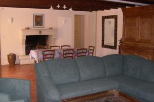 a living room with a blue couch and a table at le Moulin de Garreau in Saint-Martin-des-Fontaines