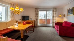 Alpenhotel Oberstdorf - ein Rovell Hotel في اوبرستدورف: غرفة معيشة مع أريكة وطاولة