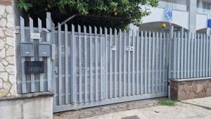 a white fence in front of a building at Casa Erre in Lusciano