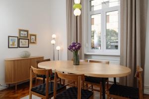 a dining room with a table and chairs and a window at Smaragd Residence Zagreb Downtown in Zagreb