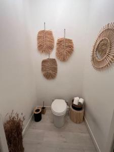een badkamer met een toilet en manden aan de muur bij Destination Confidentielle in Clermont-Ferrand