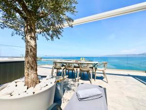 a patio with a table and chairs and a tree at Skipper Beachfront Suites in Hersonissos