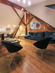 sala de estar con sofá azul y sillas en Superbe appartement esprit chalet, en Barcelonnette