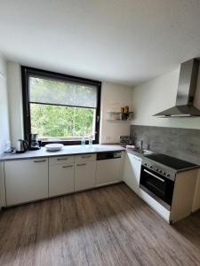 a kitchen with white cabinets and a large window at Winterberg Appartement 21097 in Winterberg