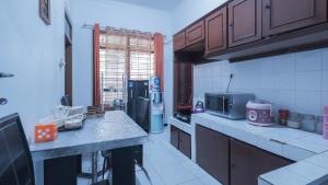 a kitchen with wooden cabinets and a microwave in it at Villa Malang Puncak Buring in Malang