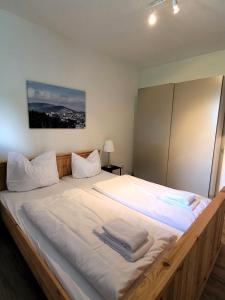 a bedroom with a large white bed with towels on it at Winterberg Appartement 21097 in Winterberg +22 photos