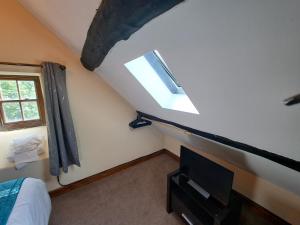 Habitación con cama, TV y ventana. en Hendre Coed Isaf Caravan Park, en Barmouth