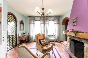un soggiorno con camino e pareti viola di Villa la Ginestra - Charming Country Rooms a Subbiano