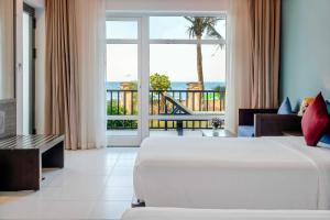- une chambre avec un lit et une vue sur l'océan dans l'établissement Tam Thanh Beach Resort & Spa, à Tam Kỳ