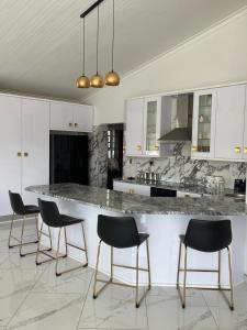 a kitchen with black chairs and a marble counter top at Avis sunrise view in Windhoek