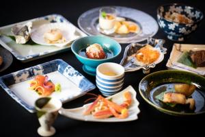 una mesa con platos de comida y tazones de comida en Intuition, en Niseko