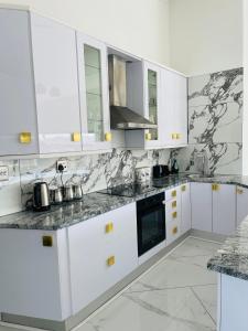 a white kitchen with black and white marble counter tops at Avis sunrise view in Windhoek