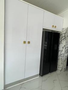 biała szafka z czarnymi drzwiami w pokoju w obiekcie Avis sunrise view w mieście Windhuk