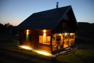 ein kleines Haus mit Lichtern auf einem Feld in der Unterkunft Planinska kuća Jovanić in Nova Varoš