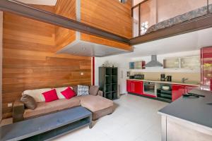 a living room with a couch and a kitchen at Le Scarlett - Maison à 300m de la plage in Palavas-les-Flots