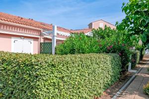 a hedge in front of a house at Le Scarlett - Maison à 300m de la plage in Palavas-les-Flots