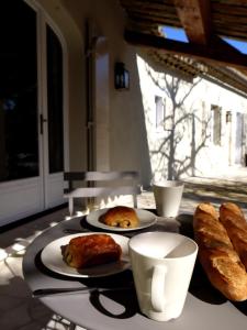 a table with two plates of bread and coffee cups at La Bergerie Provencale - Luberon - Provence - villa with heated pool in Roussillon