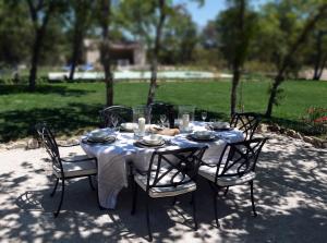 a table with a white table cloth on it with chairs at La Bergerie Provencale - Luberon - Provence - villa with heated pool in Roussillon