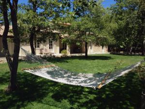 a hammock in a yard in front of a house at La Bergerie Provencale - Luberon - Provence - villa with heated pool in Roussillon