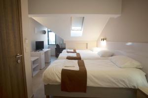 un grupo de 4 camas en una habitación con una habitación en Soul Food River Hotel e cucina en Pančevo
