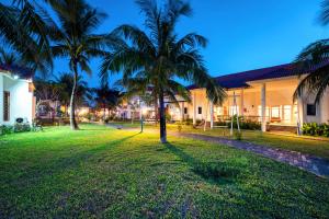 una casa con palmeras en el patio en Tam Thanh Beach Resort & Spa en Tam Kỳ