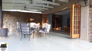 d'une terrasse avec une table et des chaises ainsi qu'un mur en pierre. dans l'établissement SnL Guesthouse at Visarend, à Malelane