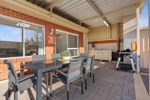 um pátio com uma mesa e cadeiras num pátio em The Shamrock House A em Renmark