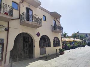 a building with balconies and doors on a street at San Raffaele Guest House in Villasimius