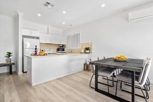 uma cozinha e sala de jantar com mesa e cadeiras em The Shamrock House A em Renmark