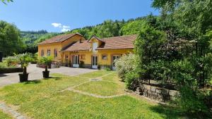 una grande casa gialla con cortile di DOMAINE DES GRAVIERS a Plainfaing