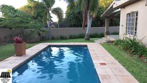 - une piscine dans la cour d'une maison dans l'établissement SnL Guesthouse at Visarend, à Malelane