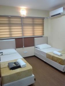 a room with two beds and a window at Bintang Square Hotel in Kubang Kerian