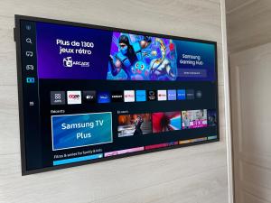 a flat screen tv sitting on top of a wall at Le mas des anges in Soussans