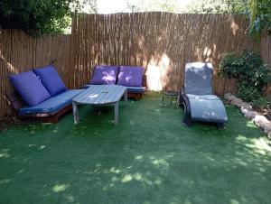 un patio trasero con 2 sofás, una mesa y 2 sillas en Orna's Corner, en Yuval