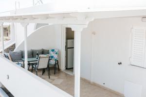 a living room with white walls and a table and chairs at Finikas Home in Kamari