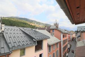a view of the roofs of buildings in a city at Superbe appartement esprit chalet in Barcelonnette