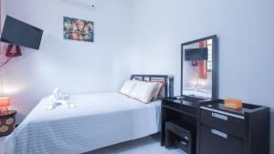 een slaapkamer met een bed en een dressoir met een spiegel bij Villa Malang Puncak Buring in Malang