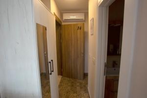 un pasillo con una puerta que conduce a un baño en Soul Food River Hotel e cucina en Pančevo