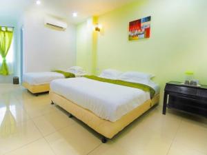 Tempat tidur dalam kamar di Asia Green Hotel
