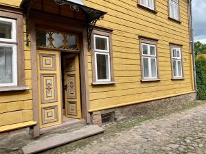 una casa amarilla con puerta amarilla y ventanas en Munga 4 Wiljandi, en Viljandi