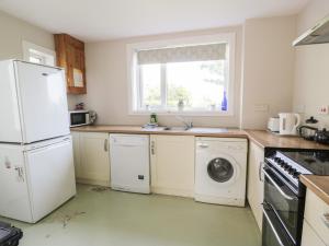 a kitchen with a white refrigerator and a dishwasher at West Lodge in Dumfries +4 photos