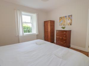 een slaapkamer met een groot wit bed en een raam bij West Lodge in Dumfries