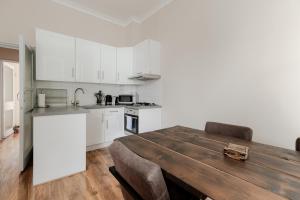 a kitchen with a wooden table and white cabinets at flat C 1-Bed Flat in Primrose Hill wont be avilbe in London