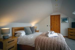 sypialnia z dużym łóżkiem z szafką nocną i łóżkiem o wymiarach sześciu w obiekcie Kirkstone Lodge w mieście Insh