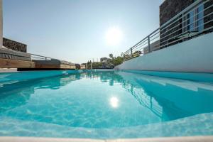 a swimming pool with a clear blue water at BlackStone Luxury Suites in Emporio Santorini