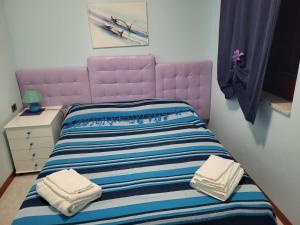聖維托羅卡波的住宿－Casa Laura，一间卧室配有粉红色的床和毛巾
