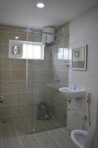 a bathroom with a glass shower and a sink at HOTEL VIRAT INN in Hyderabad